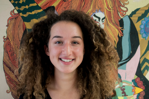 Ella Edelstein standing in front of her favorite mural at Community High. 